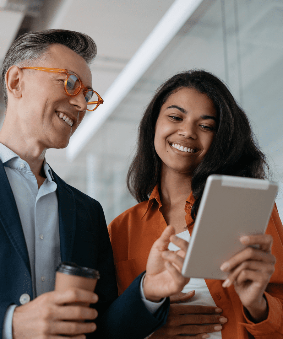GettyImages-1325566034 Two people smiling and looking at tablet.