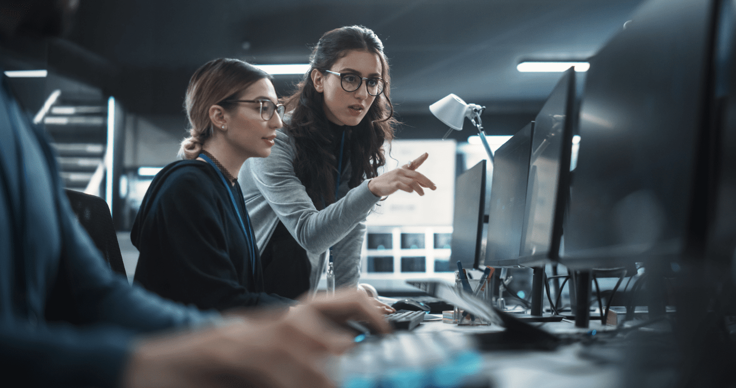 Women collaborating at computer workstations.